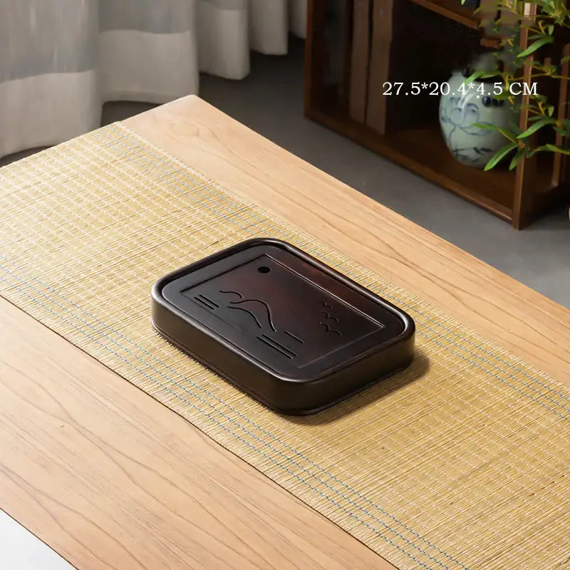 Dark brown rectangular black bamboo tea tray with subtle wave and cloud engravings for dining room drainage use