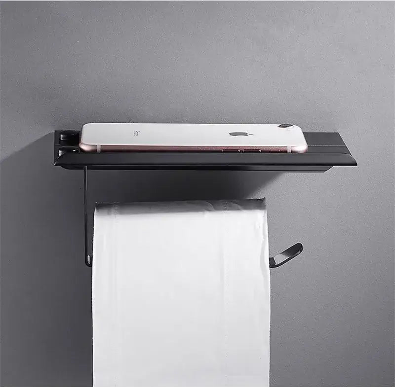 Ornate black carved aluminum toilet paper holder with wall-mounted shelf holding a white smartphone decorbites black carved