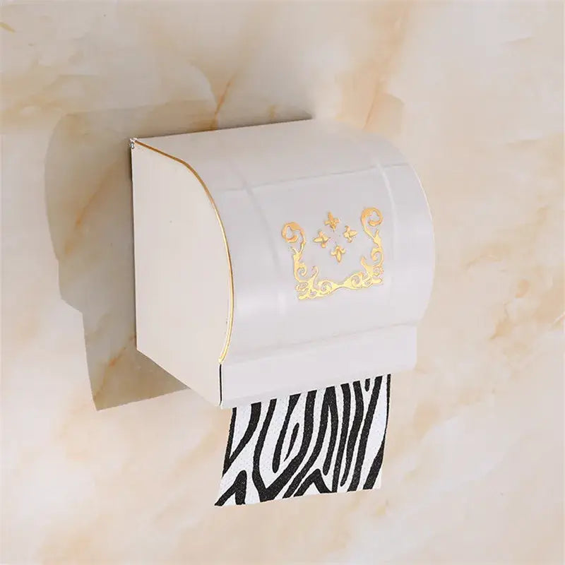 White plastic toilet paper holder with gold trim holding zebra-print roll next to ornate black carved aluminum bathroom rack decorbites black carved