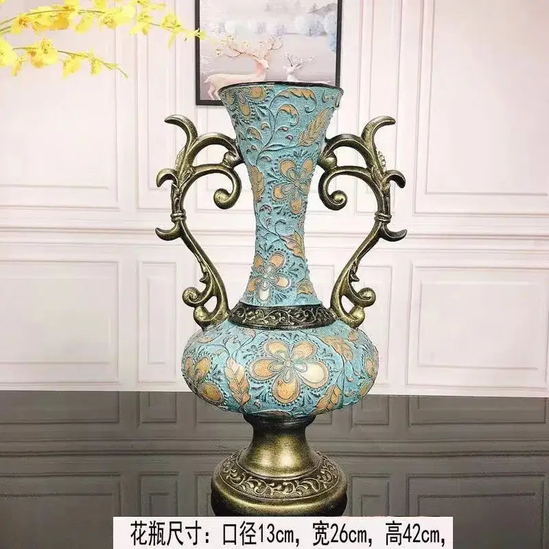 Ornate turquoise and gold resin vase dried with intricate floral patterns and curved handles for living room decor