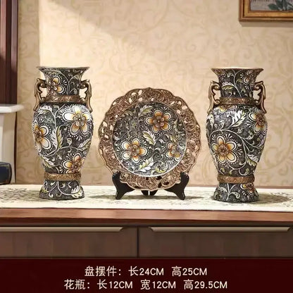 Pair of ornate black and gold resin vases with bronze handles ideal for dried flowers and living room decor