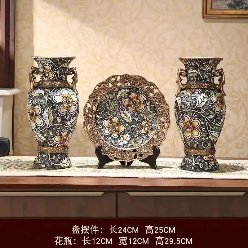 Pair of ornate black and gold resin vases with bronze handles ideal for dried flowers and living room decor
