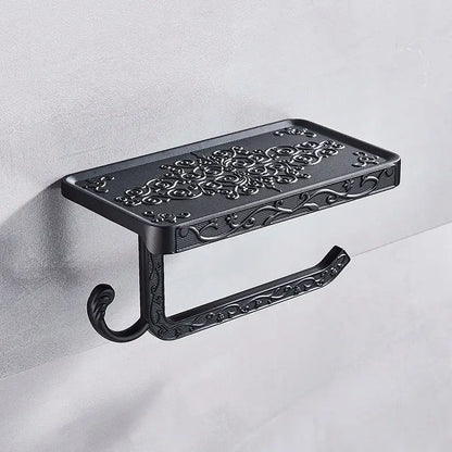 Ornate black metal toilet paper holder with intricate floral scrollwork and phone shelf for bathroom storage