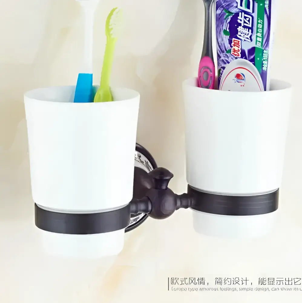 White ceramic toothbrush holder with black wrought iron mounting bracket in ornate black and white bathroom accessories set