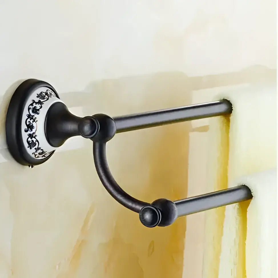 Ornate black wrought iron double towel rack with white and black floral mounting plate in bathroom accessories set