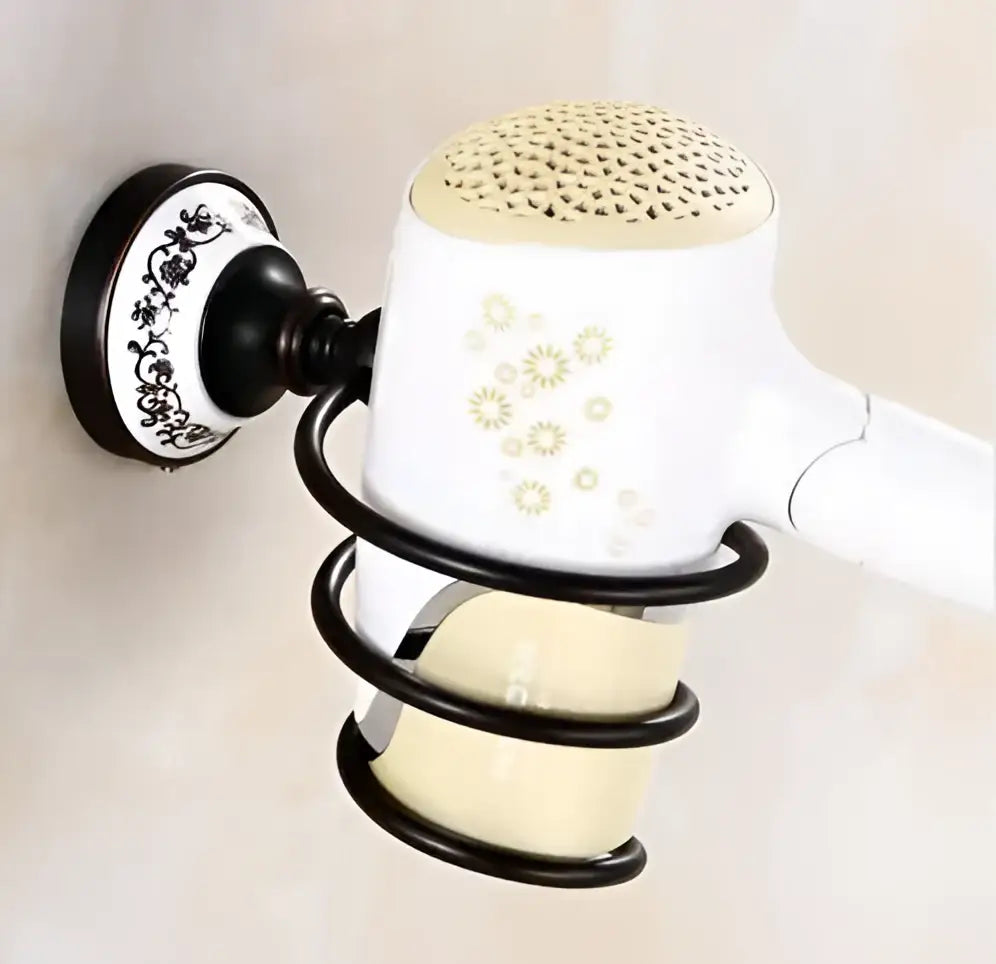 White hair dryer with gold floral decals and perforated beige top in black wrought iron holder from bathroom accessories set