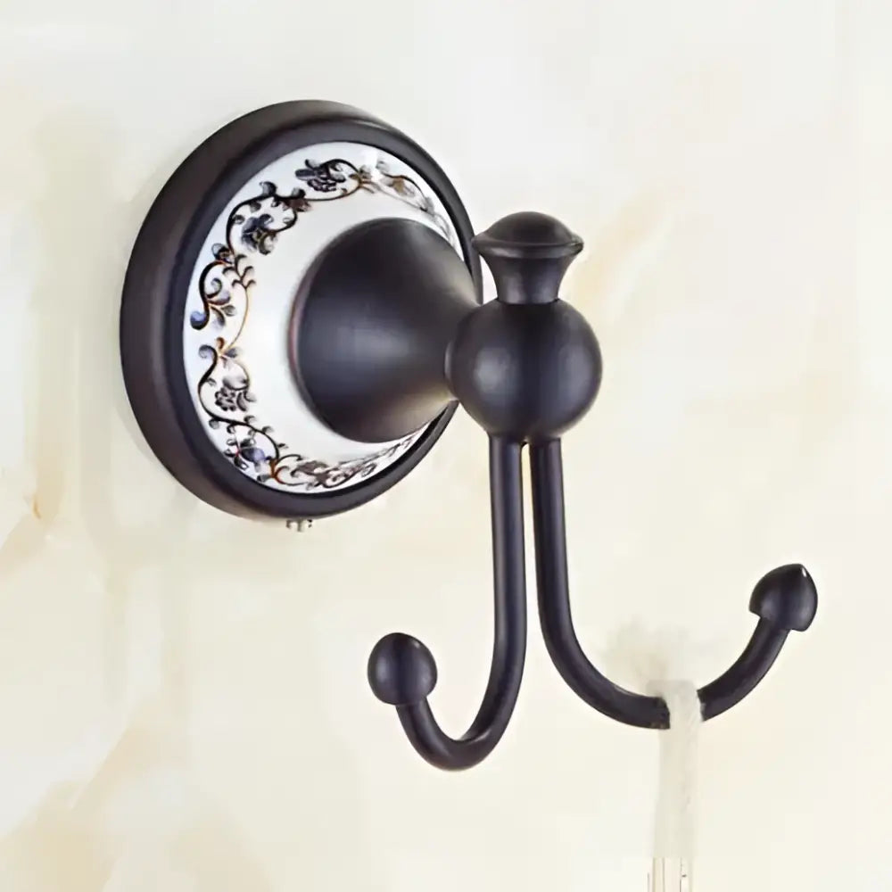 Black double hook wall mount with ornate white ceramic backplate floral design in bathroom accessories set