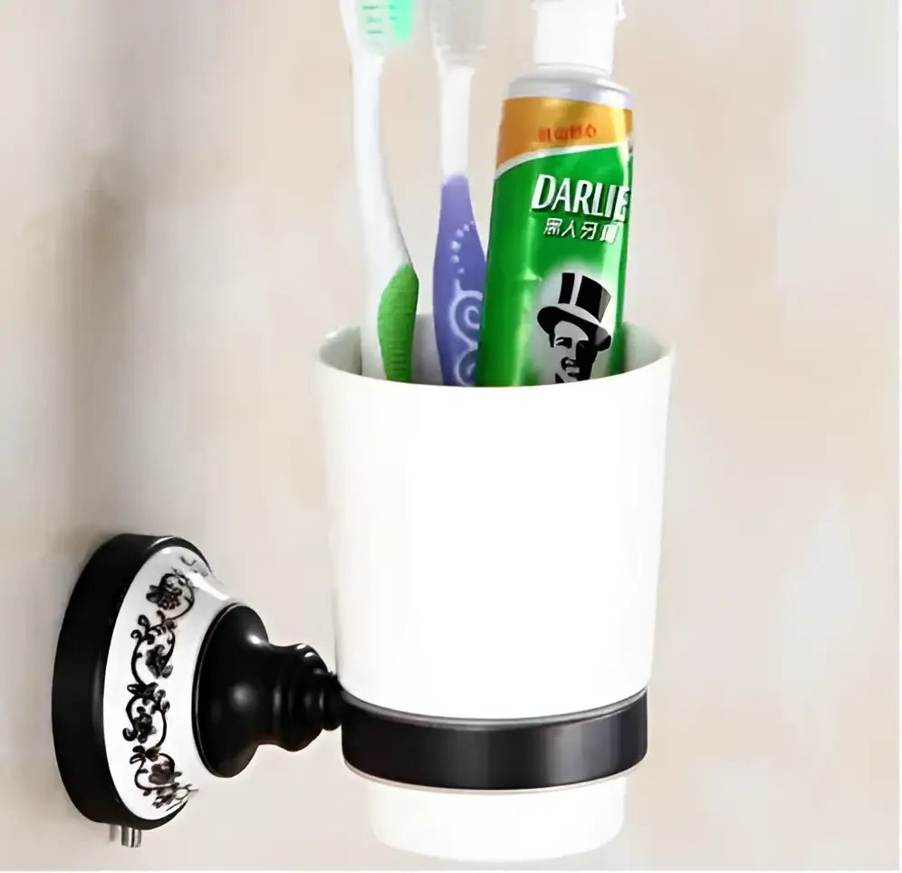 White ceramic toothbrush holder with black decorative band and ornate mounting plate from bathroom accessories set