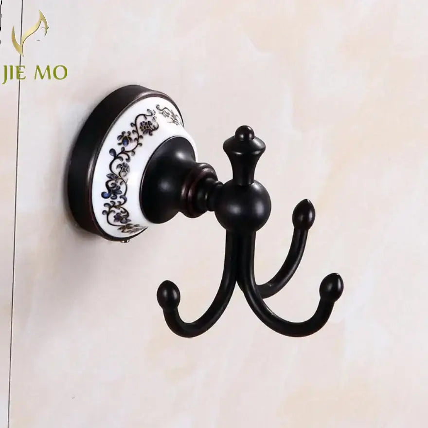 Ornate black wrought iron triple hook wall mount with white ceramic blue floral base in bathroom accessories set