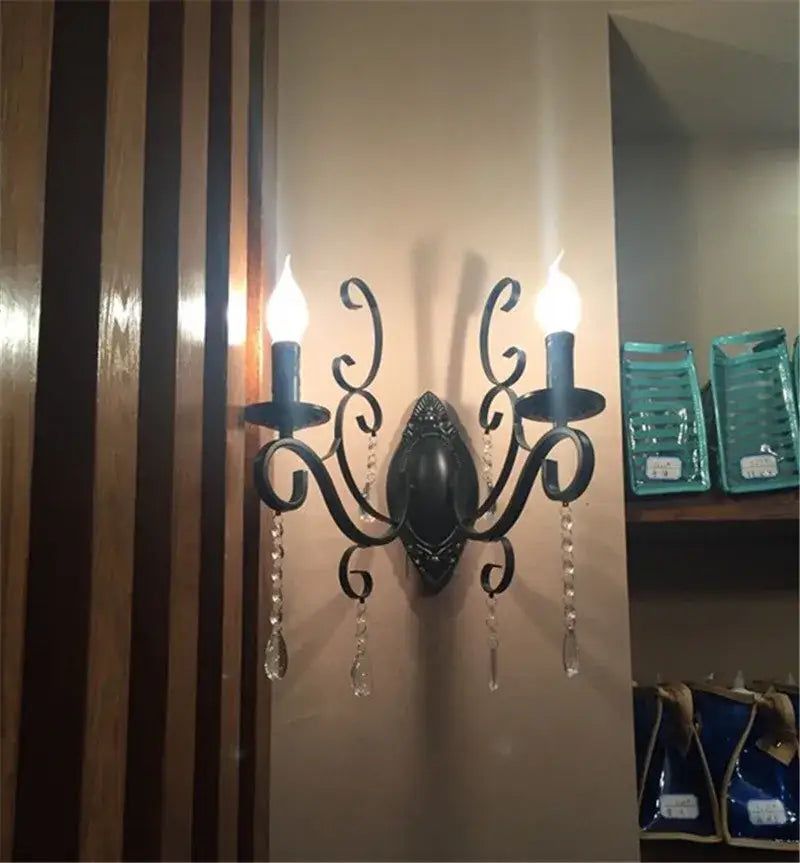 Ornate black wrought iron wall lamp with two candle-style lights and crystal droplets for living room decorbites black wrought