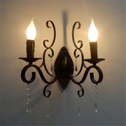 Ornate black wrought iron wall lamp with dark bronze scrollwork and crystal accents for elegant living room decorbites black wrought