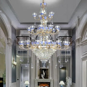 Ornate blue and gold decorbites crystal candle chandelier with crystal droplets and glass flower accents for staircase lighting