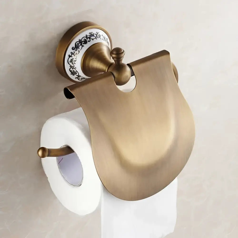 Ornate antique brass toilet paper holder with white ceramic base and curved cover in bath hardware set bathroom accessories