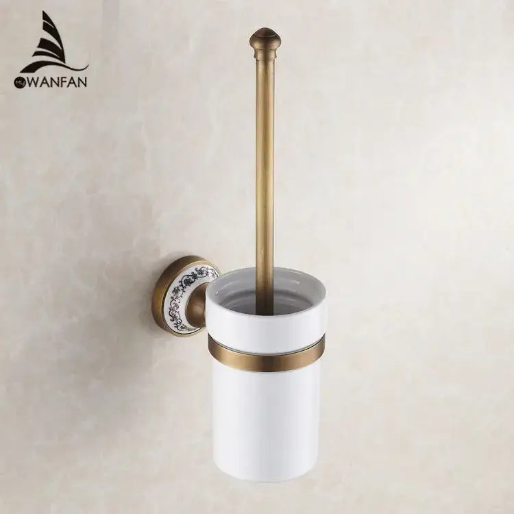 Antique brass-finished toilet brush holder with white ceramic cup and floral mounting plate in bath hardware set