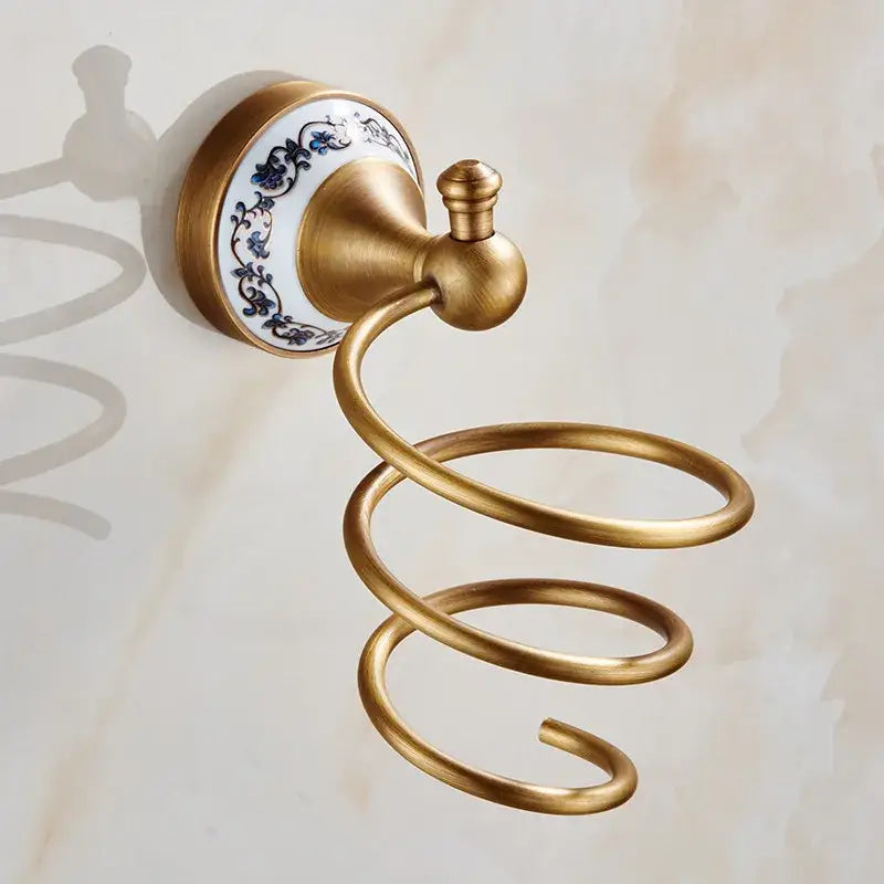 Antique brass spiral towel rack with decorative blue floral ceramic backplate in ornate bath hardware set