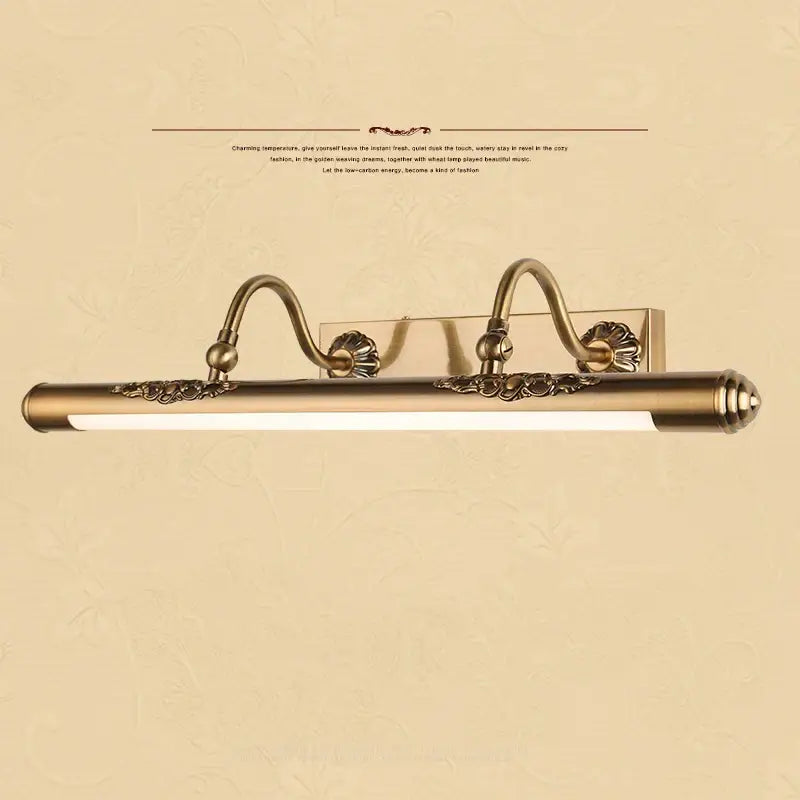 Antique brass-finished bathroom mirror lamp with ornate scrollwork and sleek elongated led bar for vanity lighting