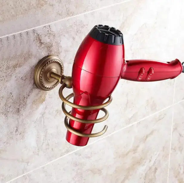 Red hair dryer with black nozzle mounted on ornate brass bracket from decorbites copper bathroom accessories set