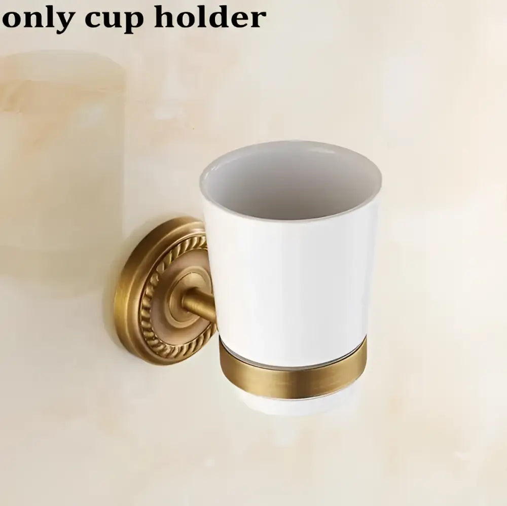 White ceramic cup holder with gold-toned metal base and decorative ring from ornate brass finished copper bathroom accessories set