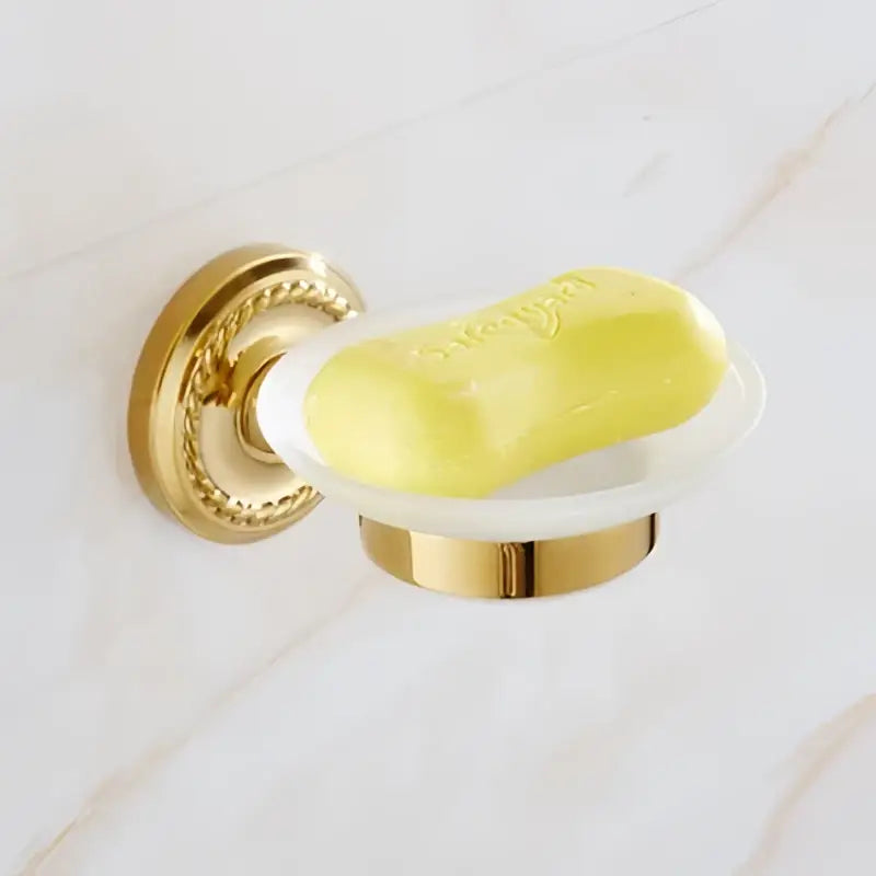 Ornate decorbites brass gold soap dish holding yellow soap bar as part of brass gold bathroom hardware set