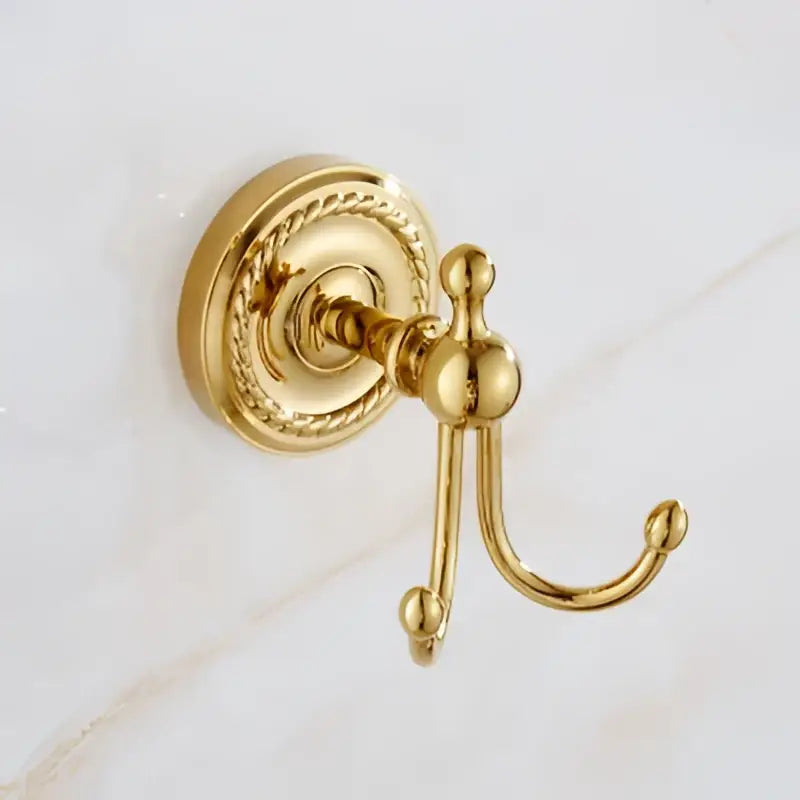 Ornate brass gold double hook towel rack with decorative circular base in polished decorbites brass gold bathroom hardware