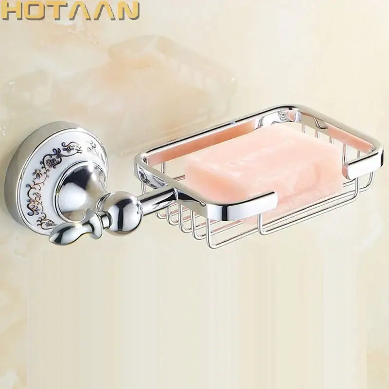 Chrome-finished wall-mounted soap dish with ornate decorative plate and wire mesh basket holding pink soap bar
