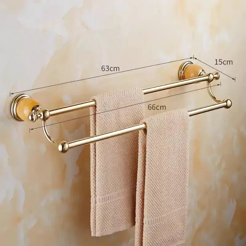 Gold-toned brass jade double towel rack with amber ceramic end caps holding beige textured towels for bathroom decorbites brass jade bathroom