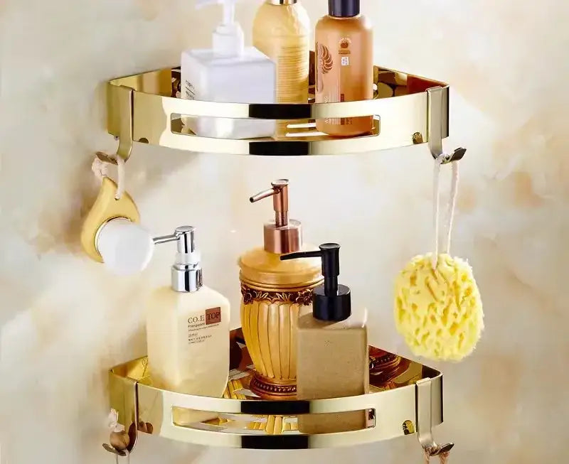 Gold-colored two-tiered brass jade corner shelf with amber accents and hooks for brass jade bathroom essentials by decorbites