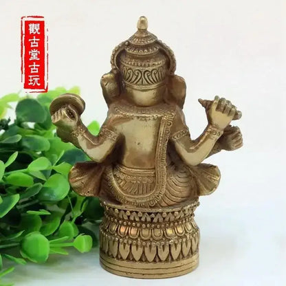 Ornate golden brass bronze ganapati elephant statue with four arms in traditional attire for living room decor