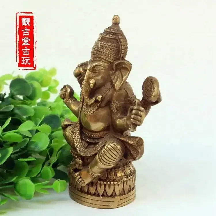 Golden brass ornate bronze ganapati elephant statue with intricate jewelry and traditional attire for living room decor