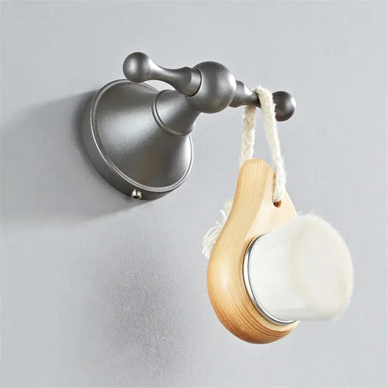 A light wood-handled facial brush with white bristles and silver rim from ornate brushed nickel gray bathroom accessories set