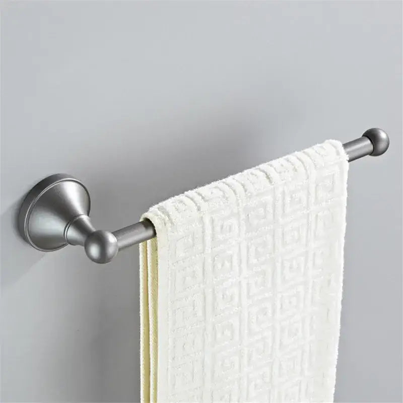 A sleek brushed nickel towel rack with a white textured towel in an ornate gray bathroom accessories set decorbites gray bathroom