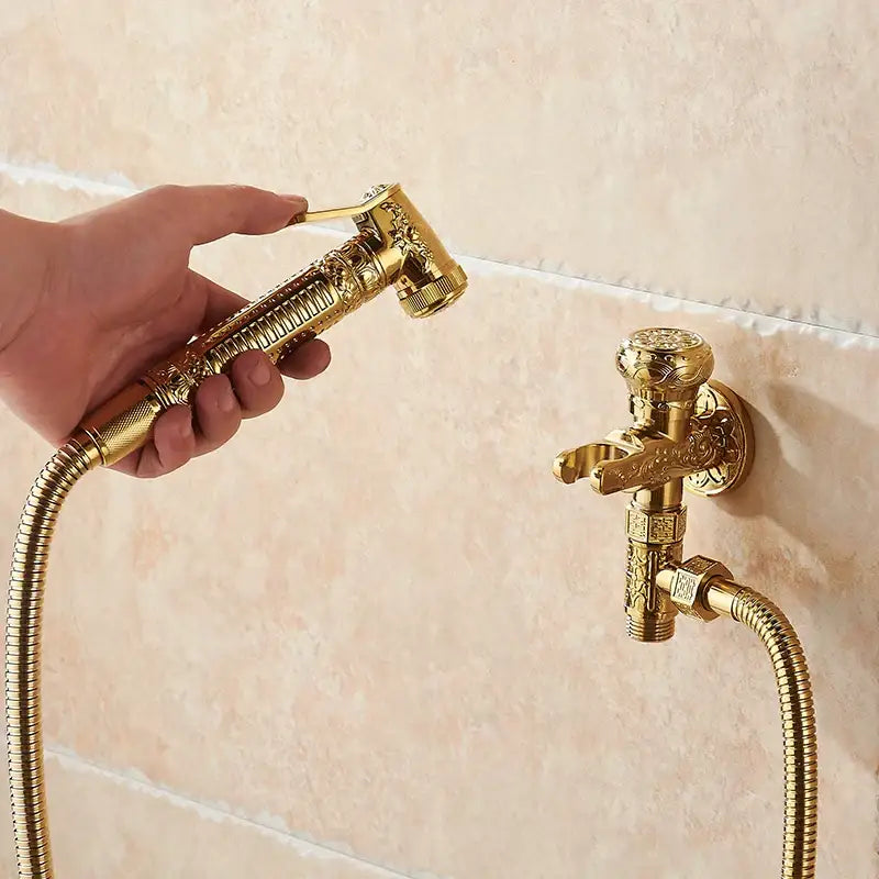 Ornate engraved gold brass wall mounted bidet faucet and sprayer with intricate floral decorbites brass wall design