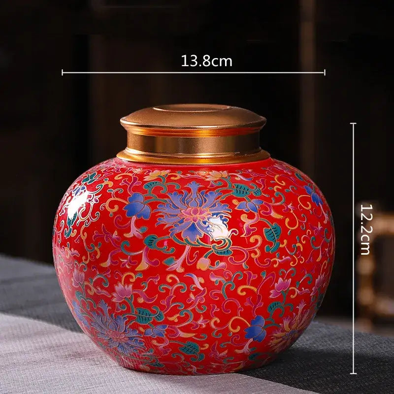 Vibrant red ceramic storage jar with gold lid and intricate blue green pink floral patterns for tea or coffee