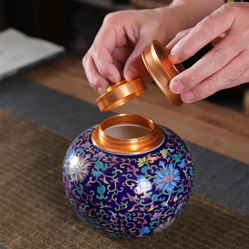 A vibrant purple ceramic storage jar with intricate floral patterns and a matching golden lid for tea or coffee