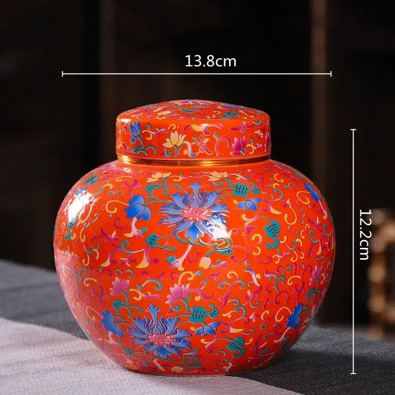 Vibrant orange ceramic storage jar with intricate blue pink and green floral patterns ideal for tea storage