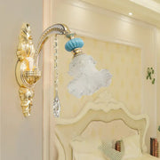 Ornate gold-toned wall mount light with blue glass globe and frosted crystal lampshade for bedroom use