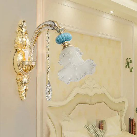 Ornate gold-toned wall mount light with blue glass globe and frosted crystal lampshade for bedroom use