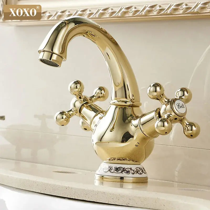 Ornate gold and chrome double handle chrome basin faucet with curved spout and cross-shaped handles for bathroom use