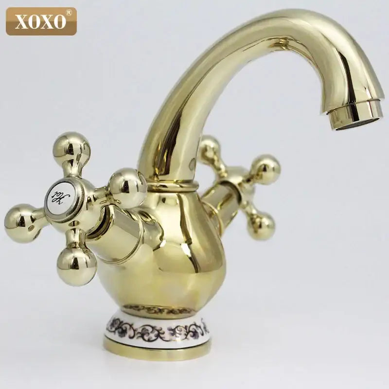 Ornate gold finished brass double handle chrome basin faucet with cross handles and decorative ceramic base for bathroom
