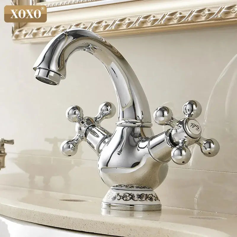 Chrome finished xoxo basin faucet with ornate double handle chrome cross-shaped handles and decorative scrollwork base