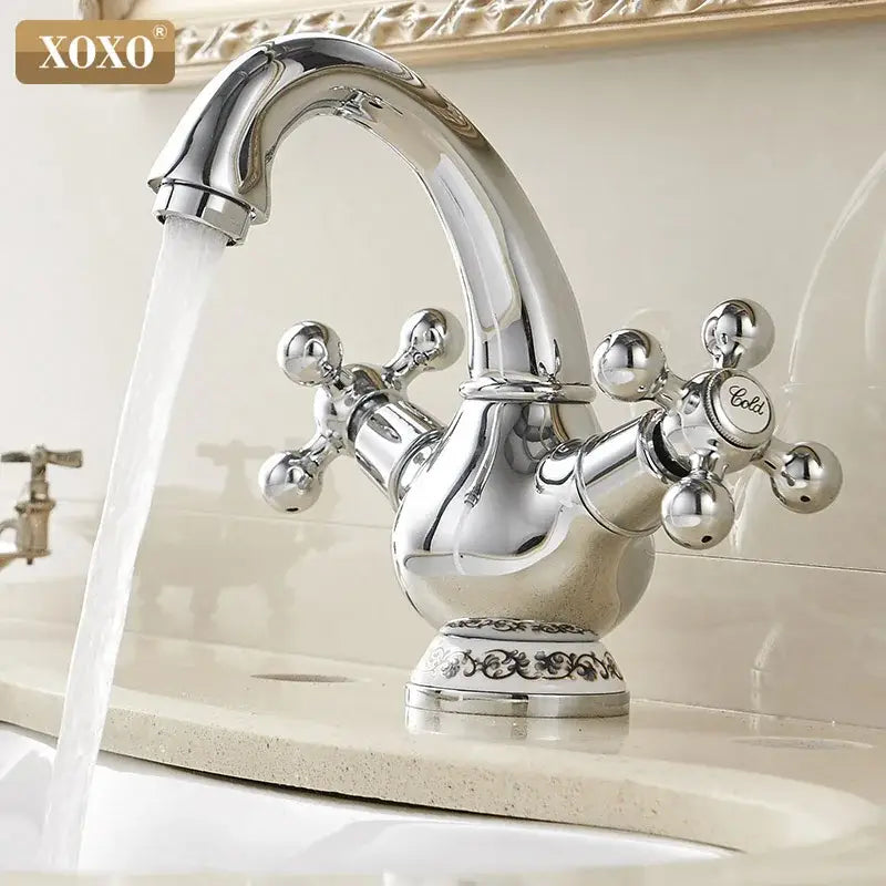 Ornate gold and chrome double handle chrome basin faucet with xoxo brand cross-shaped handles for bathroom use