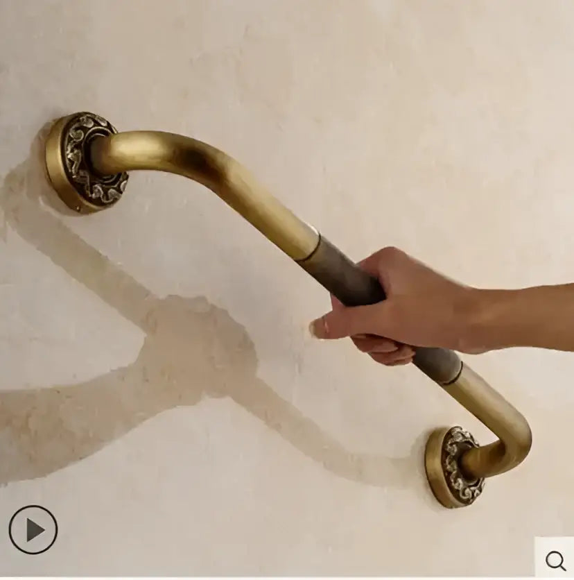 Brass-finished wall-mounted grab bar with ornate decorative end caps from decorbites copper carved bathroom accessories set