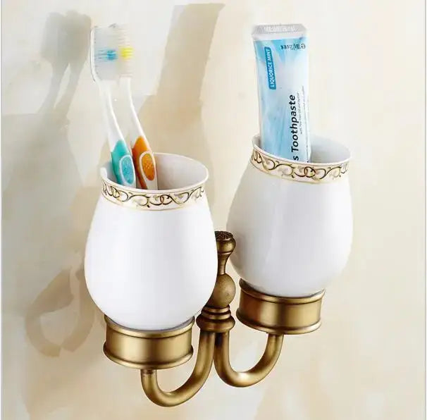 White ceramic toothbrush holder with gold ornate detailing and brass base from decorbites copper carved bathroom set