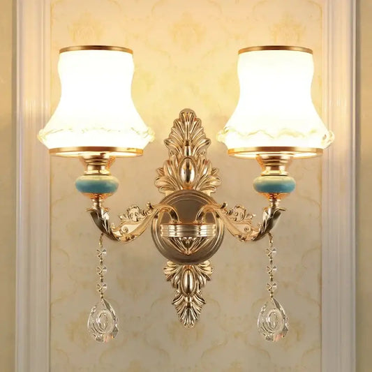 Ornate gold crystal wall sconce with two frosted shades and dangling teardrop pendants for bedroom decorbites wall sconce