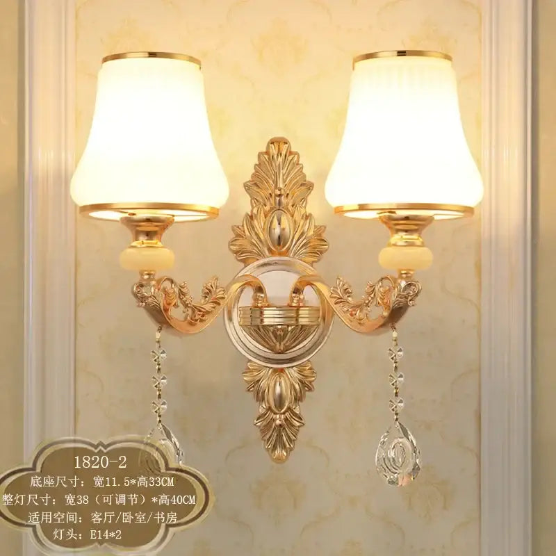 Ornate gold crystal wall sconce with two cream frosted shades and dangling teardrop pendants for elegant decorbites decor