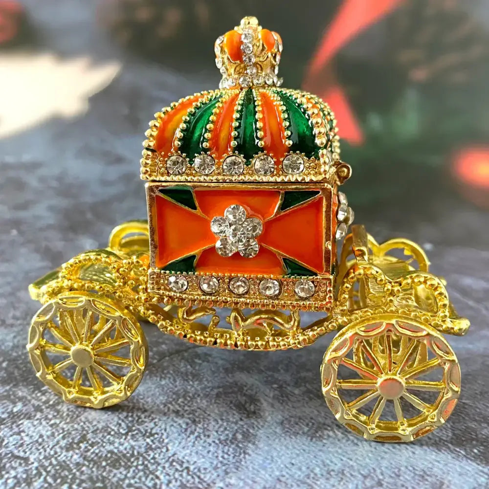 Ornate gold enamel crown jewelry box carriage with orange and green accents and rhinestones for bedroom decor
