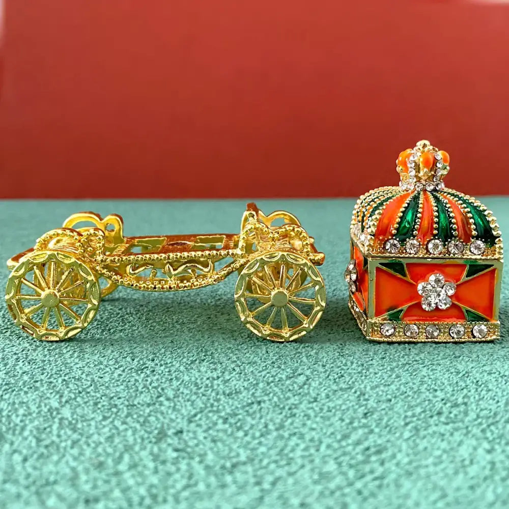 Ornate gold carriage jewelry box with orange and green enamel crown accents for elegant enamel crown jewelry storage