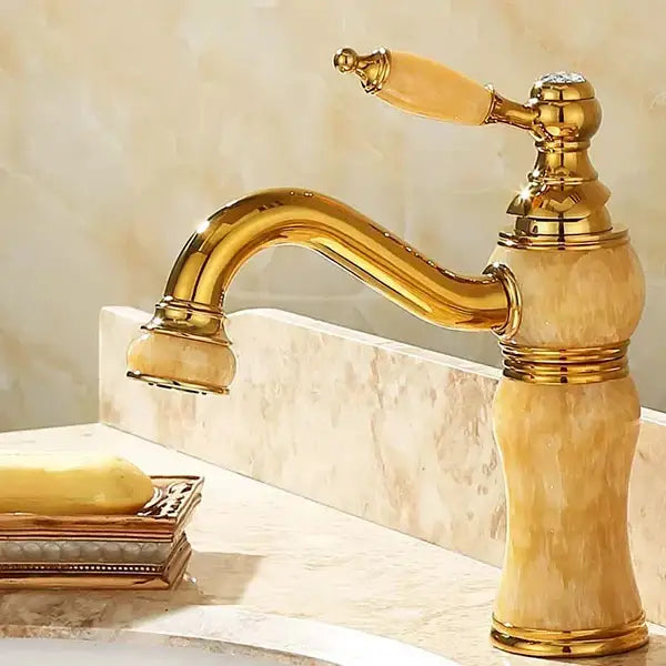 Ornate gold bathroom basin sink faucet with curved spout and amber marble accents featuring jade bathroom basin design