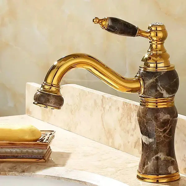 Ornate gold bathroom basin sink faucet with jade green and dark marble accents in polished brass finish