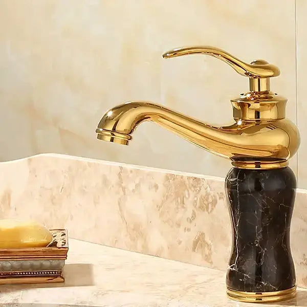 Ornate gold basin sink faucet with a sleek curved spout and black marble base for jade bathroom basin use